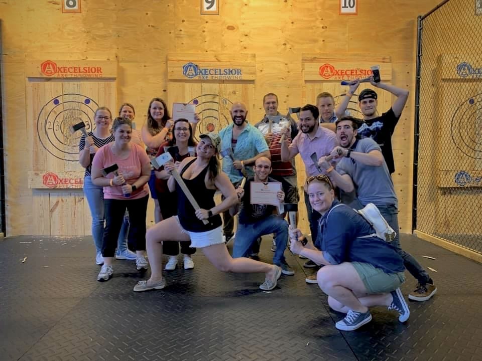 friends holding axes in fun poses at Axecelsior Axe Throwing in Orlando, FL