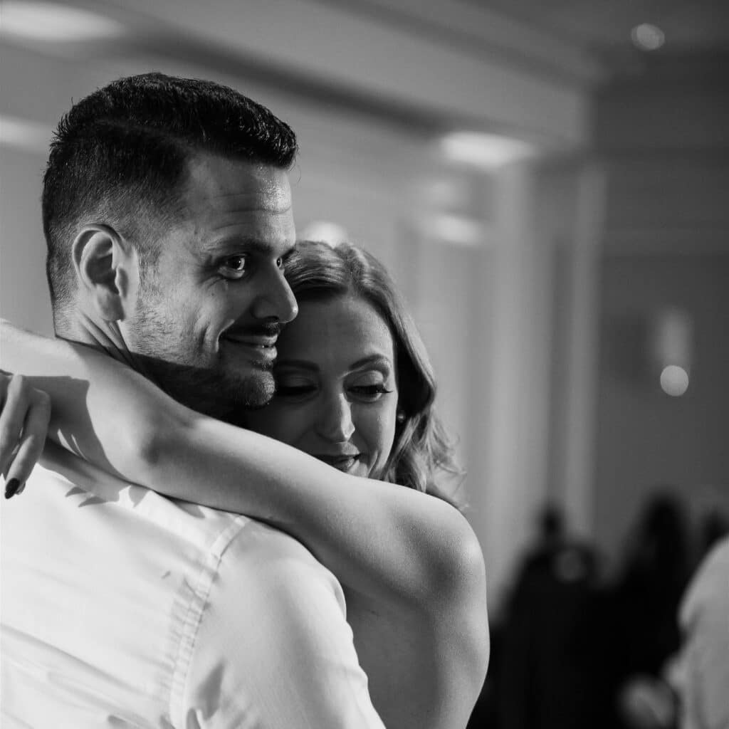 Black and white photo of bride and groom slow dancing at a wedding