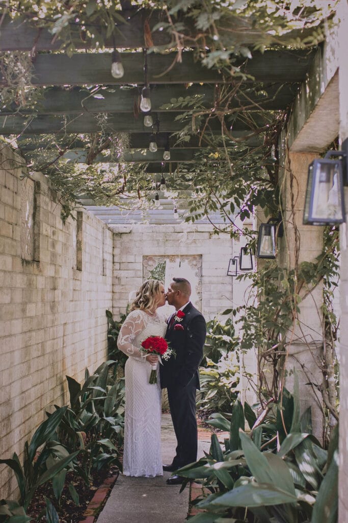 Bride and Groom kissing in brick corridor