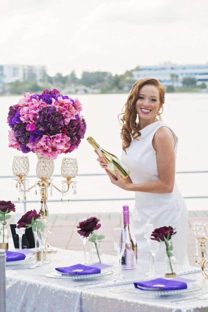 bride smiling holding a gold reflective bottle of wine from ABC Fine Wine & Spirits