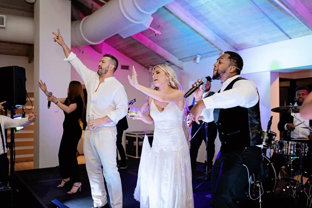 Bride and groom singing with the band