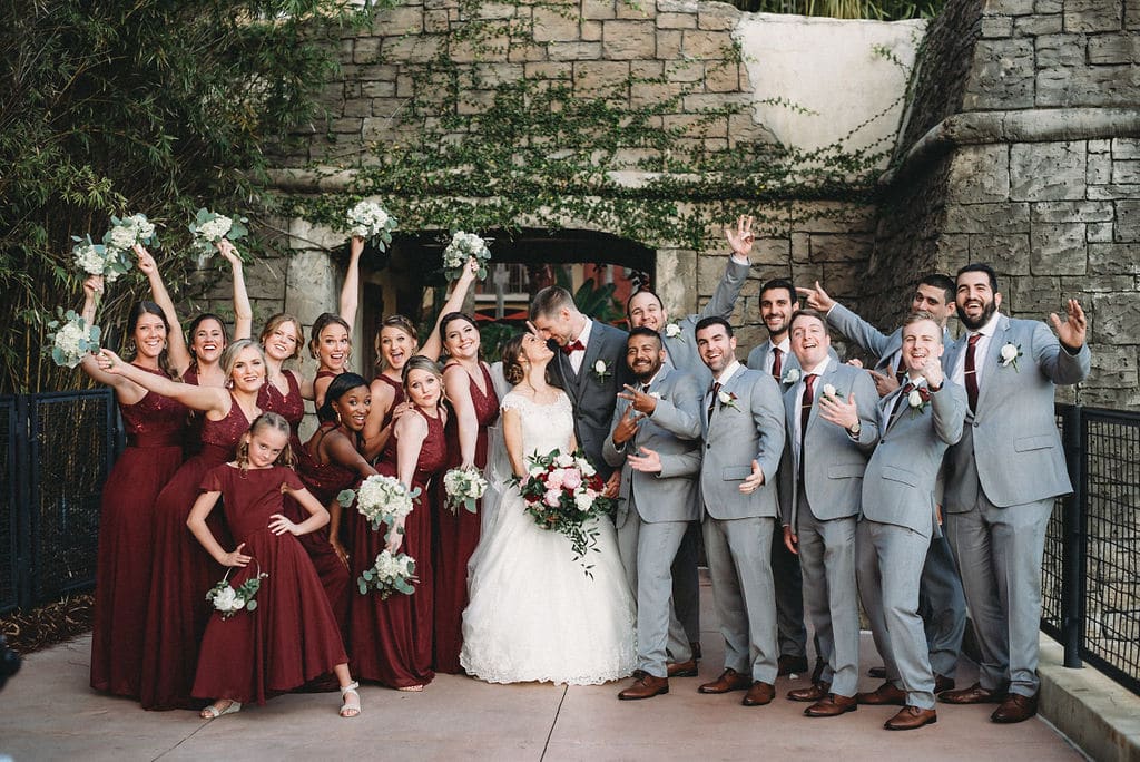 bride and groom standing with their bridal party striking funny poses