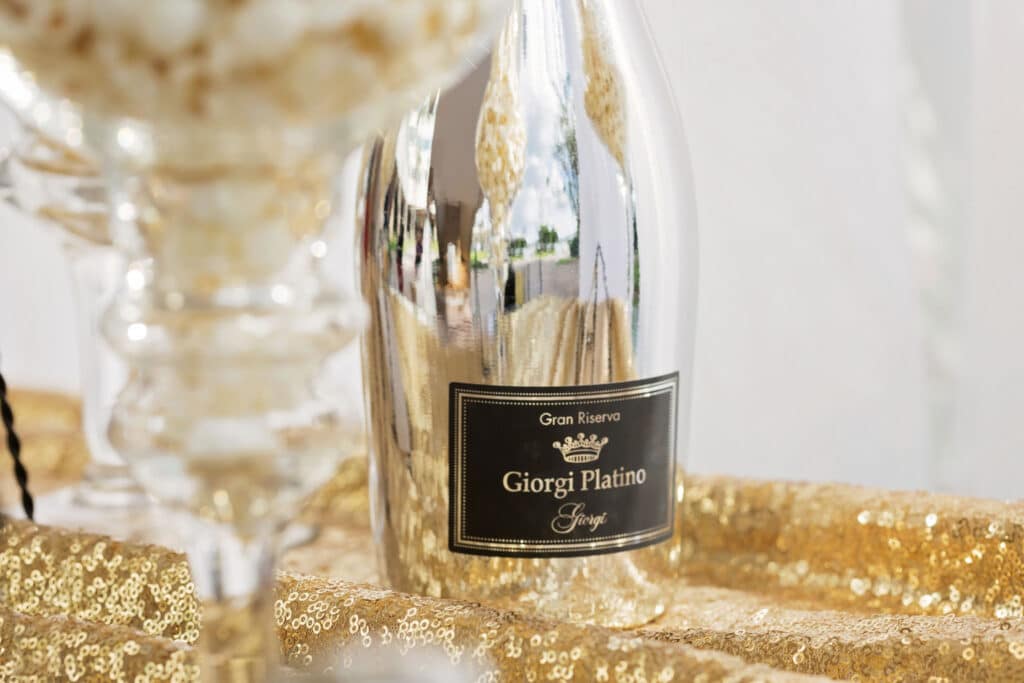 reflective wine bottle on a gold sparkly linen at a wedding
