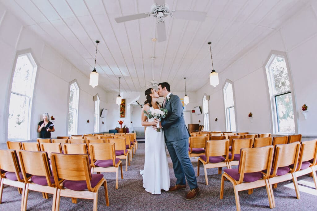 Bride and Groom in aisle of wooden chairs