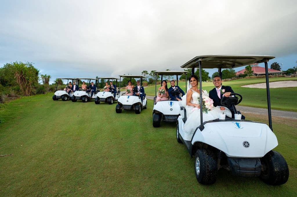 bride and groom and their bridal party riding in golf carts