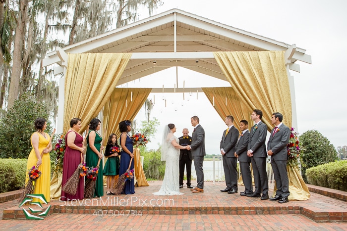 outdoor wedding ceremony with bridesmaids in autumnal colors and groomsmen in grey