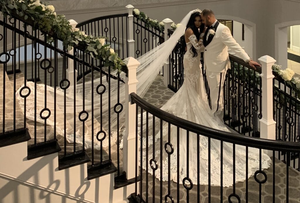 bride and groom standing on staircase landing