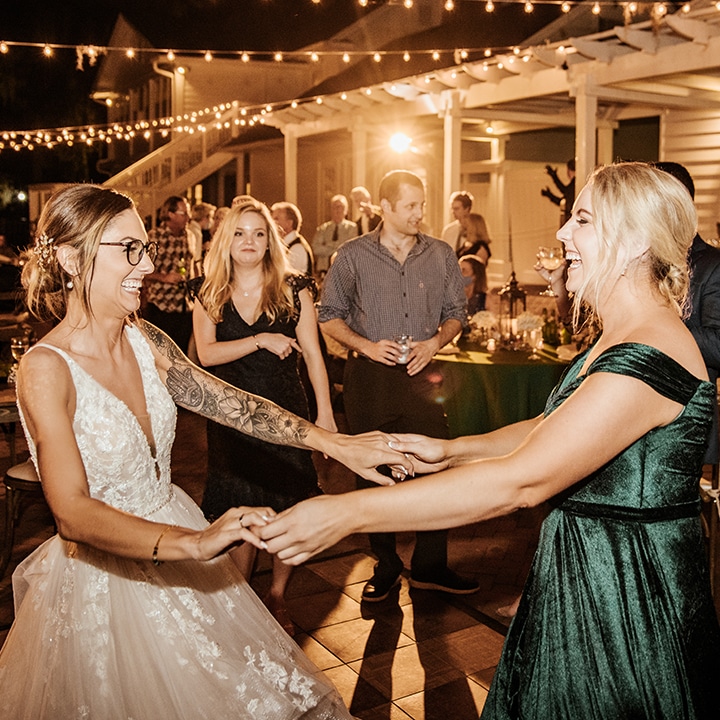 Bride dancing and laughing with guest