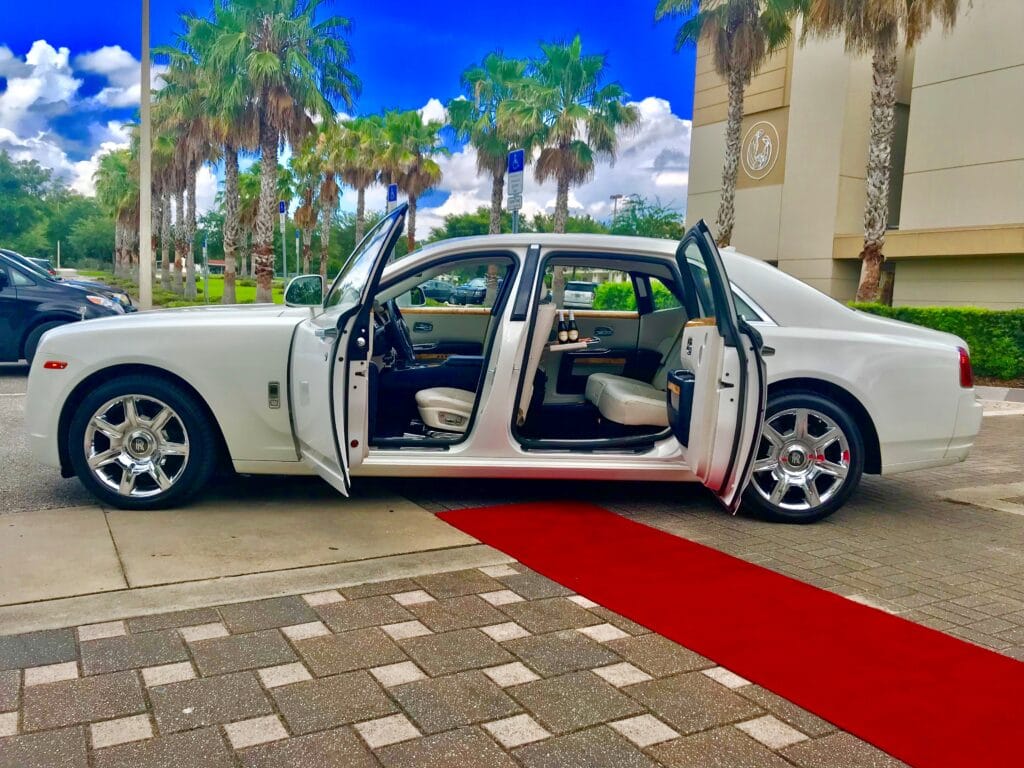 doors open on white car with red carpet