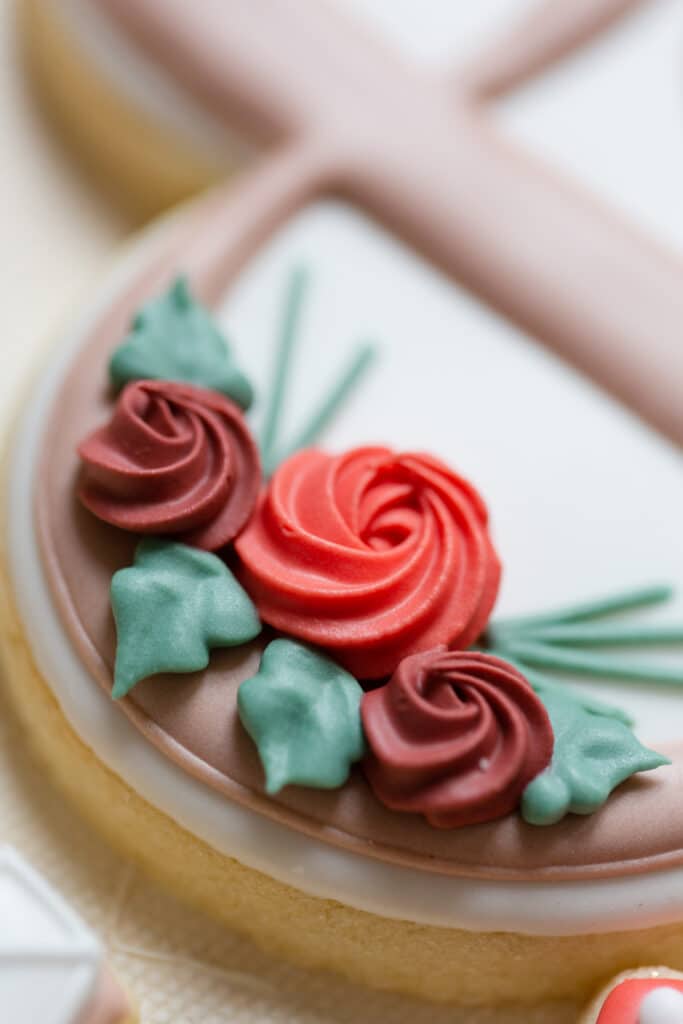 Christmas in July SS 116 - Christmas Themed Wedding Inspiration - Inspiration Shoot a close up of the red flowers on the cookies with green leaves surrounding the flower