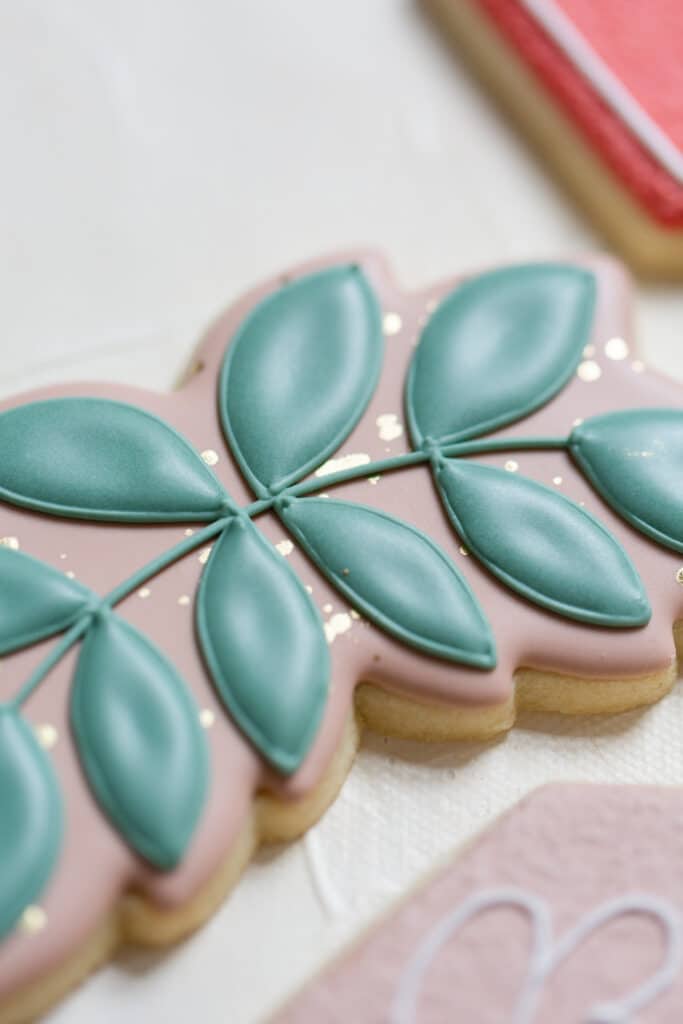 Christmas in July SS 123 - Christmas Themed Wedding Inspiration - Inspiration Shoot a close up of a cookie designed with frosting to look like leaves for the christmas themed wedding inspiration shoot.