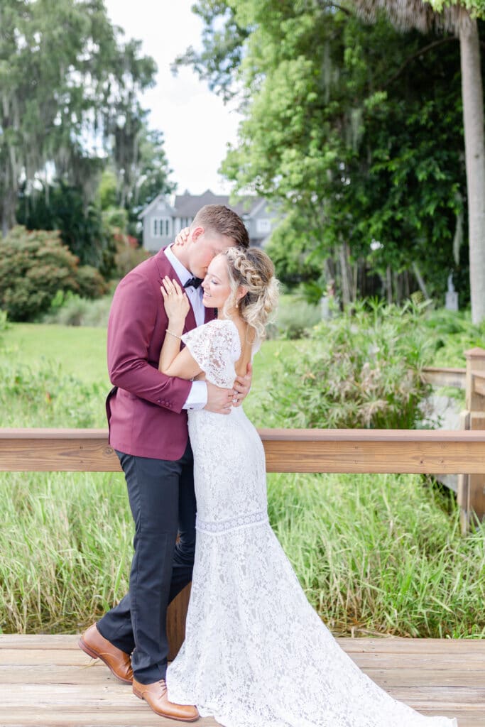 Christmas in July SS 145 - Christmas Themed Wedding Inspiration - Inspiration Shoot bride and groom getting close while standing on the dock of the capen house for the christmas themed wedding inspiration shoot.