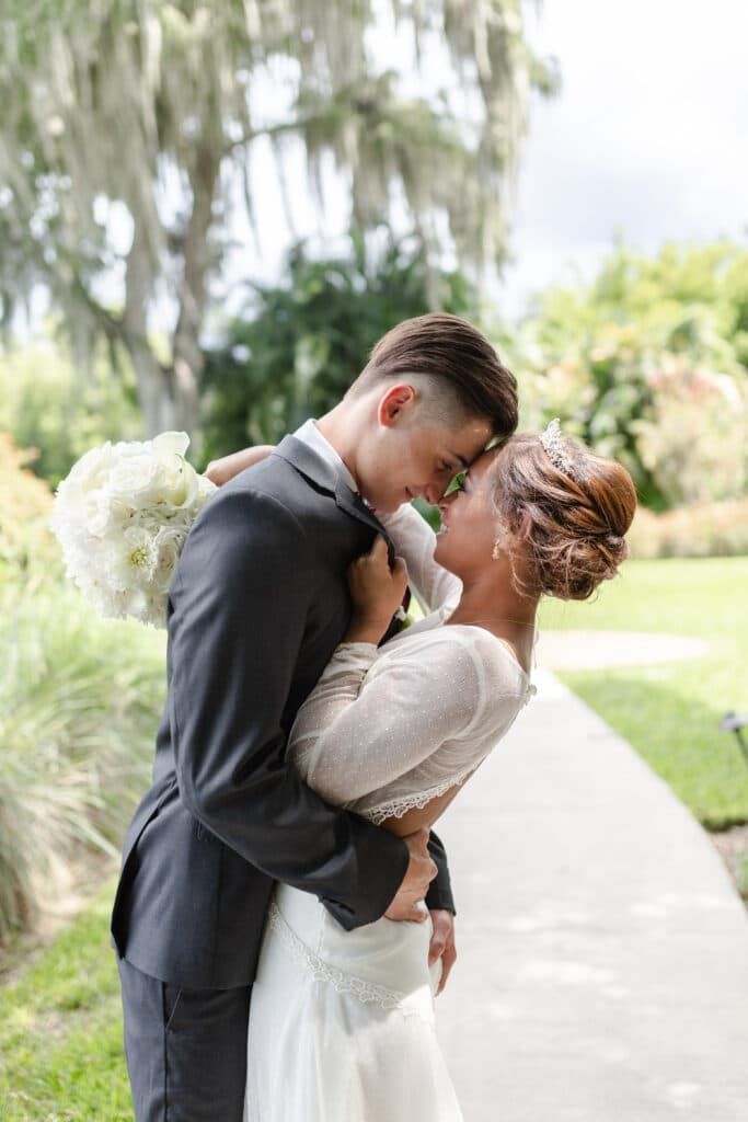 Christmas in July SS 162 - Christmas Themed Wedding Inspiration - Inspiration Shoot bride pulling the groom in close by the collar of his suit and the groom placing his forhead on the brides