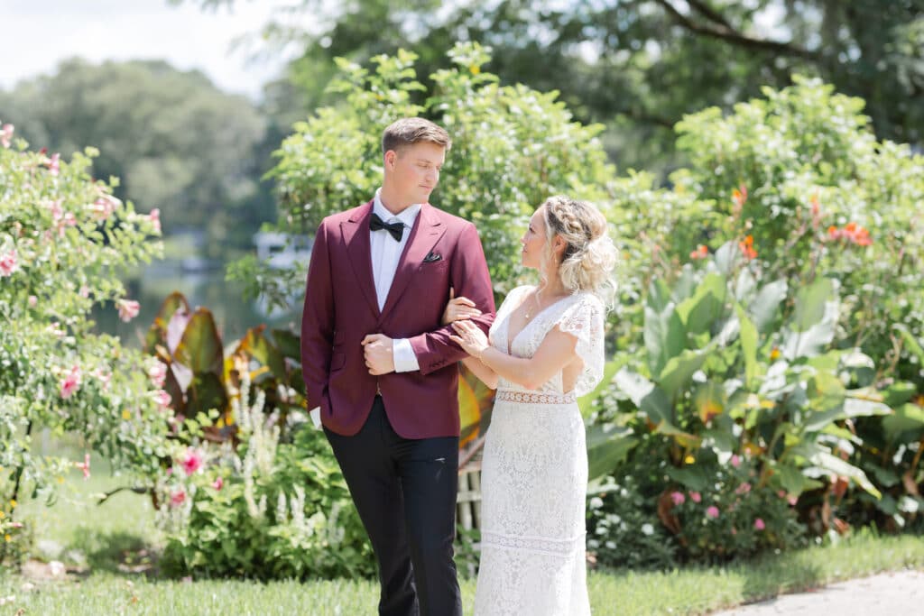 Christmas in July SS 24 - Christmas Themed Wedding Inspiration - Inspiration Shoot Bride and groom walking together in a garden.