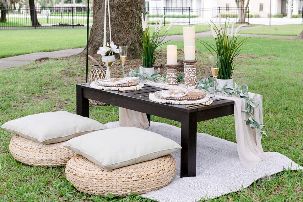 the picnic table with two dining sets, candles, pillows and florals
