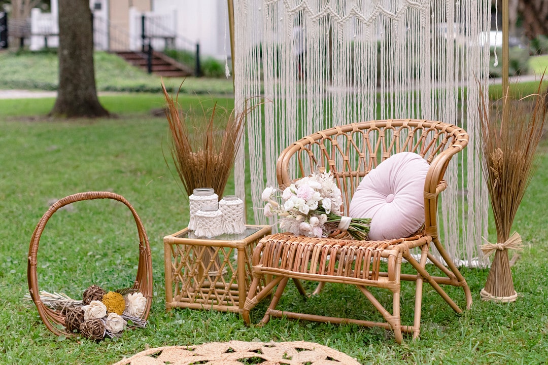 the macrame backdrop with wicker furniture decorated with pink decor