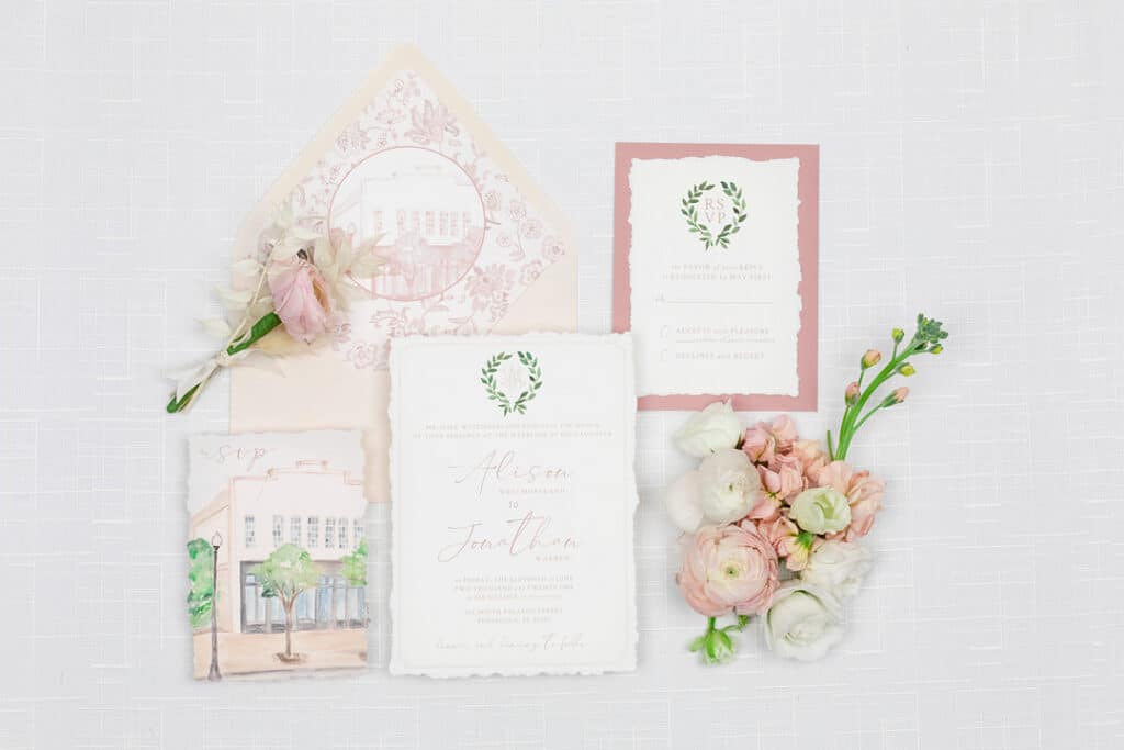 the rsvp cards for the wedding surrounded by pink florals for the picnic wedding inspiration shoot.