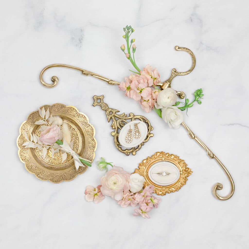 gold platters and a gold hanger with pink and white florals surrounding
