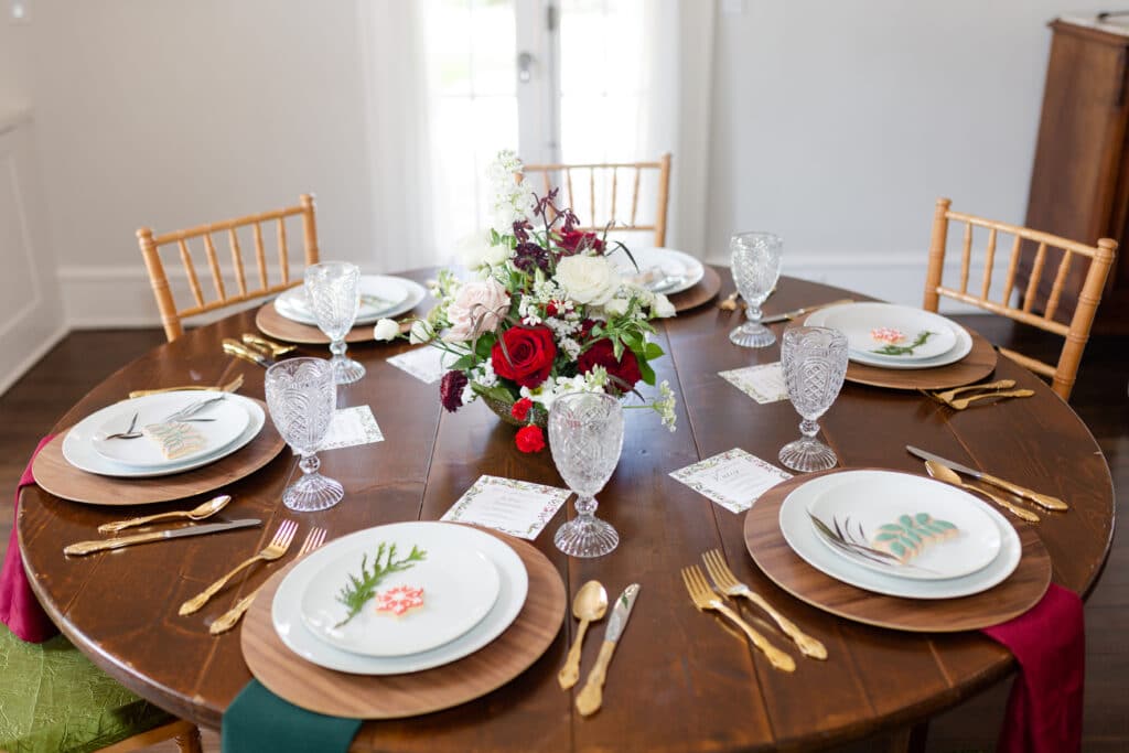Sneak Peak 16 - Christmas Themed Wedding Inspiration - Inspiration Shoot a large round table set for six people with red, green, white and gold accents