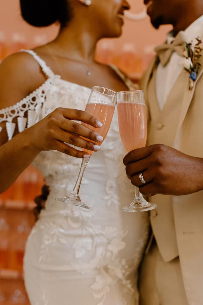 Summer Urban Loft Wedding Inspiration Grace Jicha Venue At The Block Wedding BrideandGroom 43 websize low - Urban Loft Wedding Inspiration - Styled Shoot close up of the pink champagne in the couple's glasses as they cheers