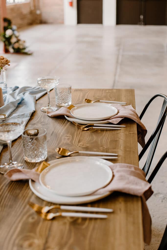 Summer Urban Loft Wedding Inspiration Grace Jicha Venue At The Block Wedding Tablescape 15 websize low - Urban Loft Wedding Inspiration - Styled Shoot the reception table with pink napkins and gold silverware.