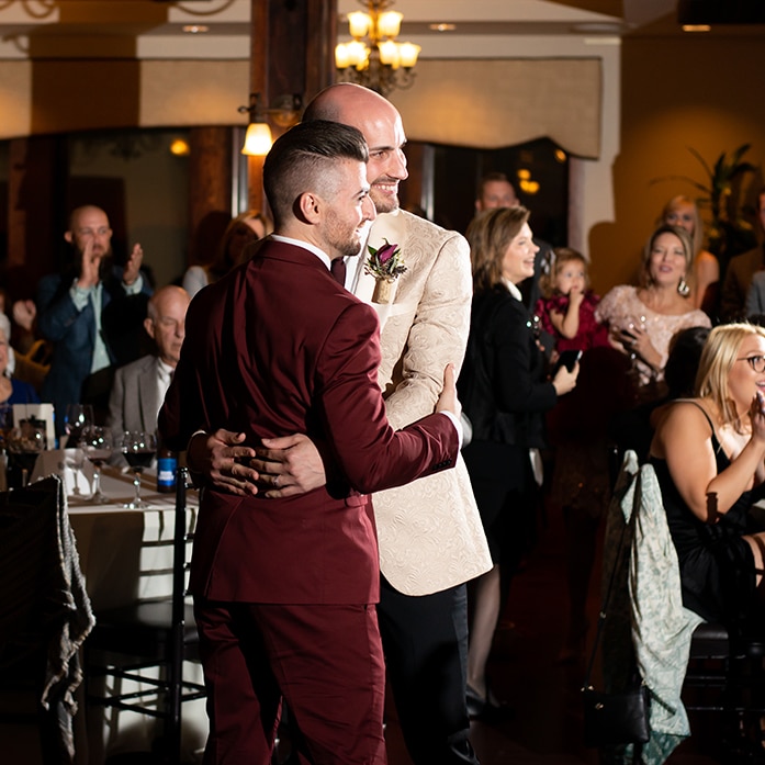 Grooms embracing at their wedding.