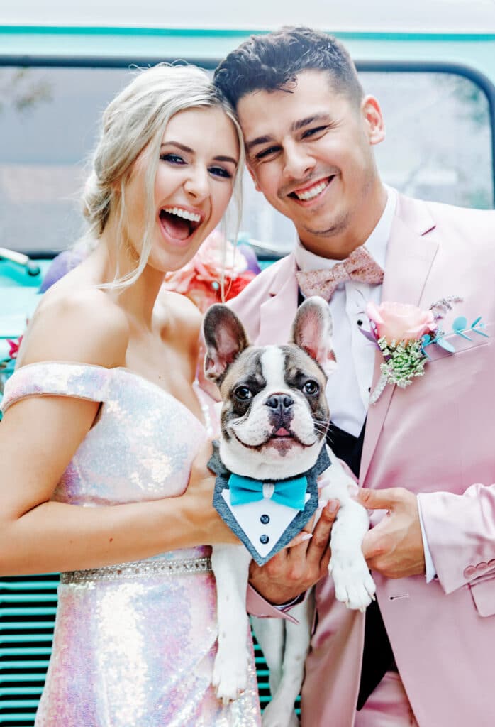 Bride and Groom pose with dog in wedding regalia