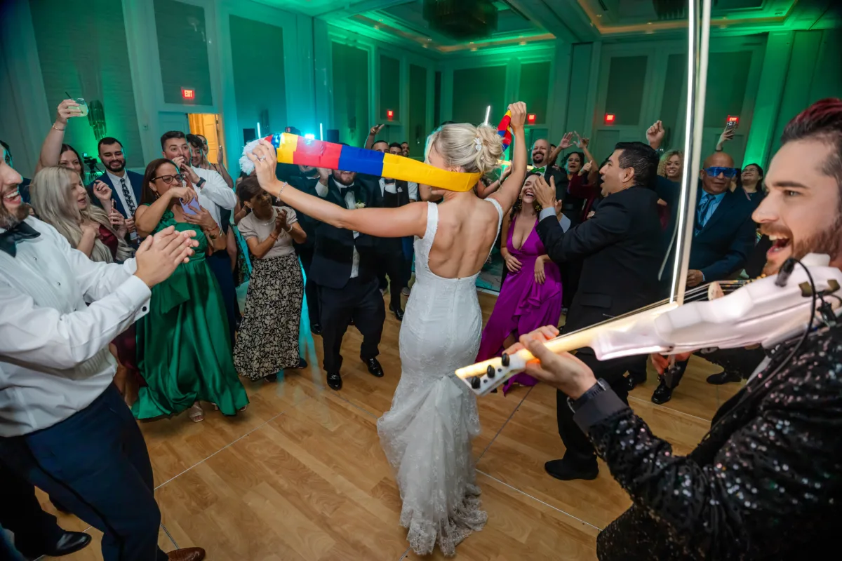 Couple and wedding guests celebrating Hora Loca on the dance floor at Waldorf Astoria Orlando.