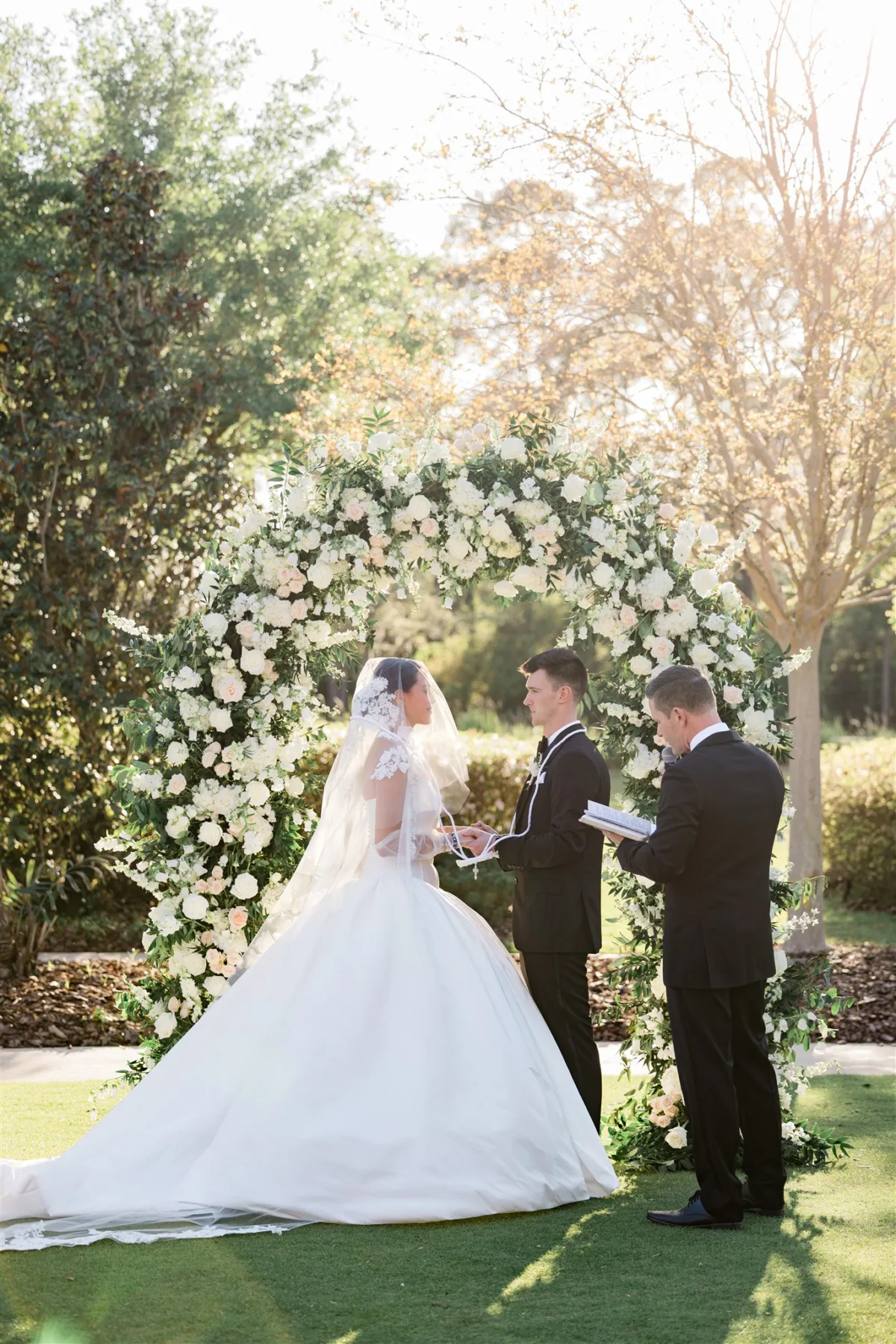 Couple exchanging vows at the altar during an outdoor wedding ceremony on King Meadow Lawn at Four Seasons Resort Orlando.