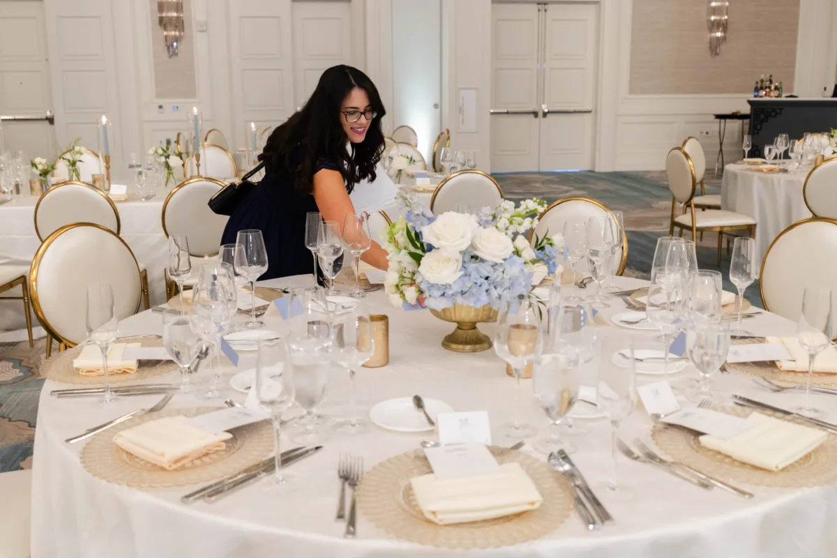 LT Events wedding planner adding final details to a reception table at Waldorf Astoria Orlando.