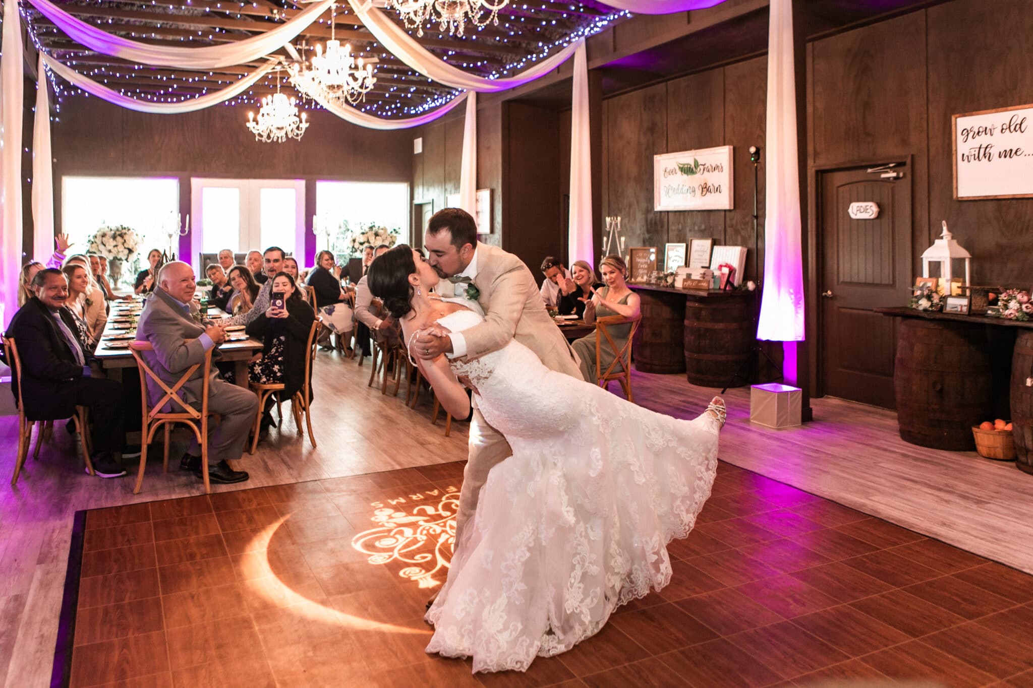 the groom dipping his bride during the first dance during the classic barn wedding.