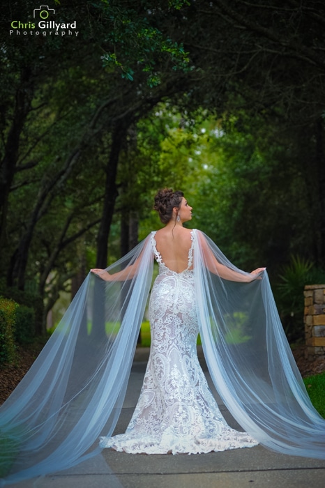Bride under trees with mermaid silhouette wedding dress.