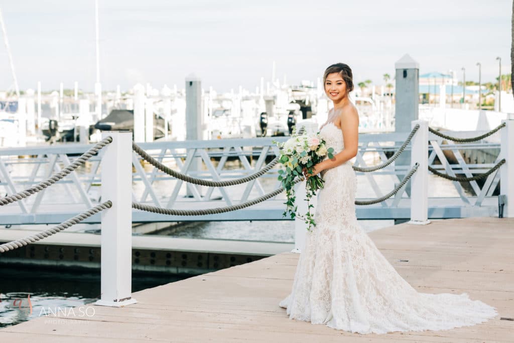 Bride at marina pier with white bouquet