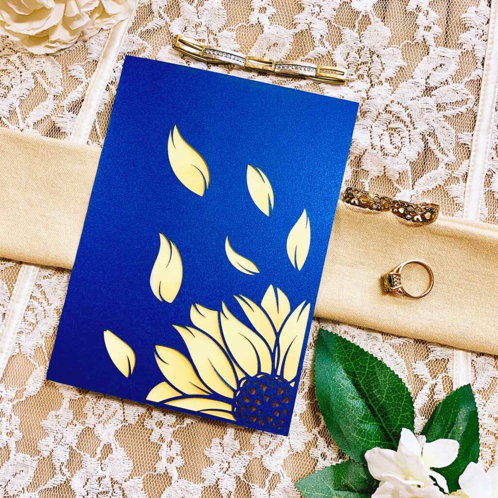 blue notecard with yellow sunflower and petals