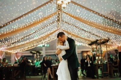 22 rentaland tents and eventsbf99fc09cdadb1d89f97a52893f16b8c - Rentaland Tents and Events Bride and groom embracing under twinkle lights