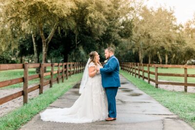 A bride and groom embracing at a stable