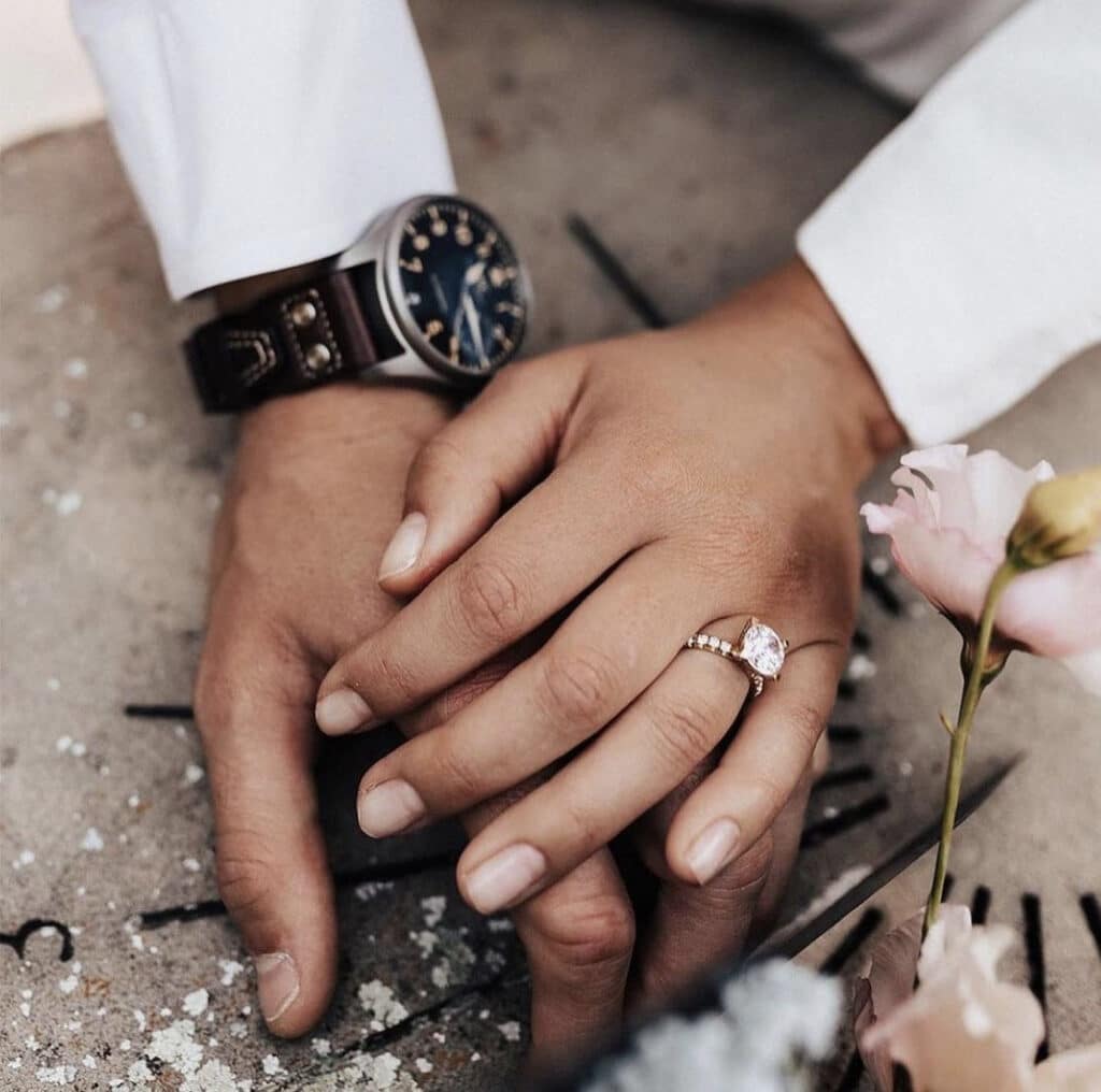 Man and woman's hand with wedding ring and watch