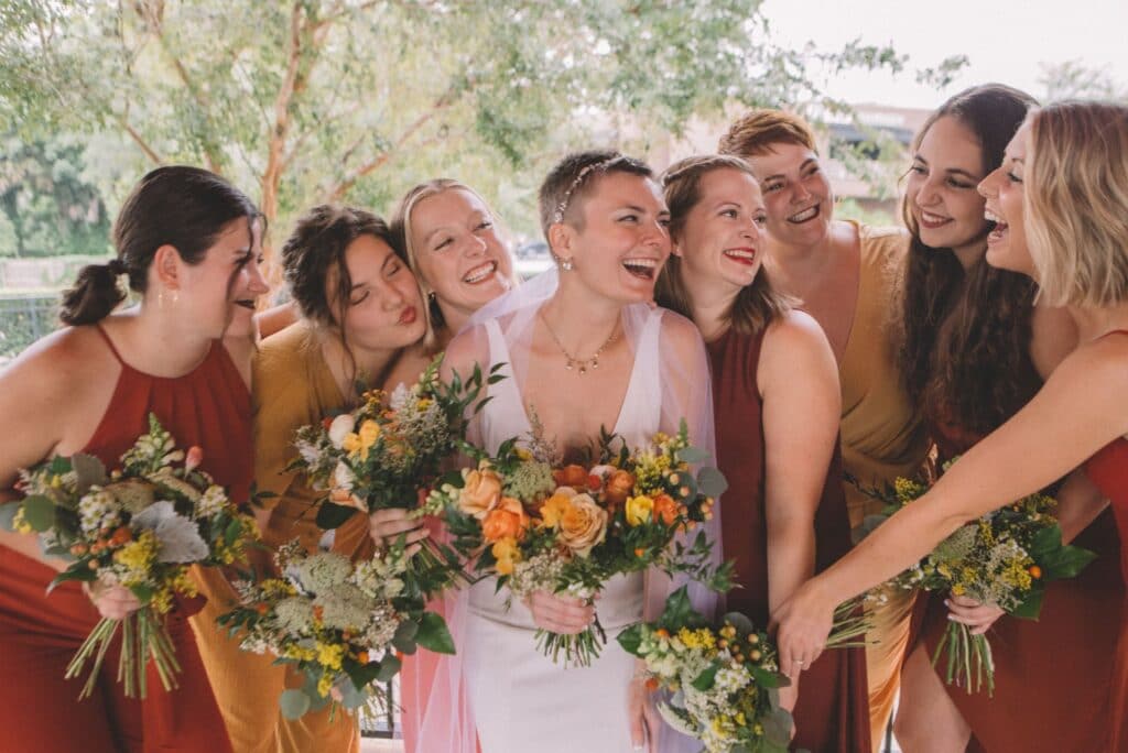 bride laughing with attendants dressed in fall colors