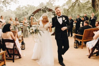 A bride and groom walking down the aisle after being married