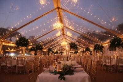 Clear tent with string lights outside at night