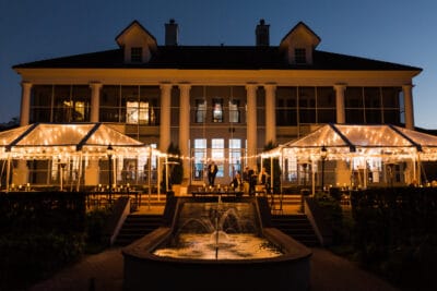 View of venue outside at night. There is a fountain in the front.