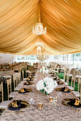Table settings under a tent at a wedding