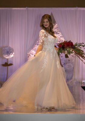 A beautiful bride fans her dress while holding her bouquet