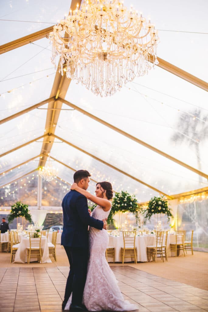 Bride and groom dancing under a chandelier