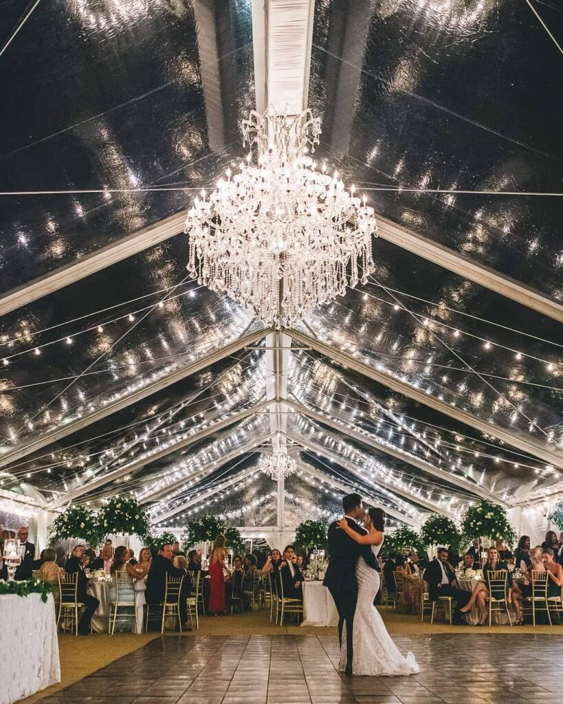 Bride and groom sharing their first dance under a tent outside
