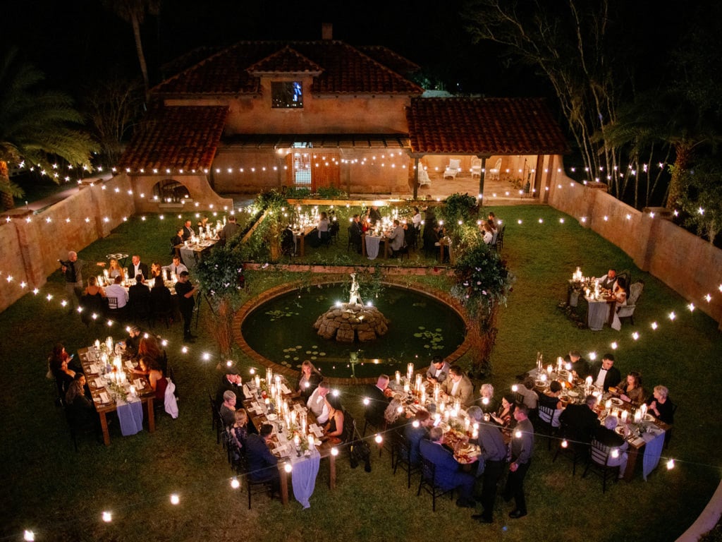 Aerial view of wedding reception. The guests are sitting down eating.