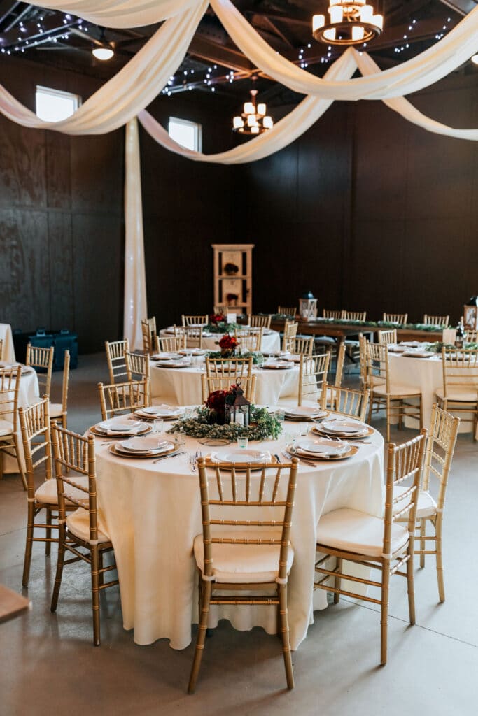 wedding reception with gold chairs and white draping