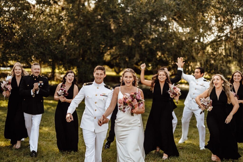Bridal party smiling for the camera. The groom and groomsmen are in uniform
