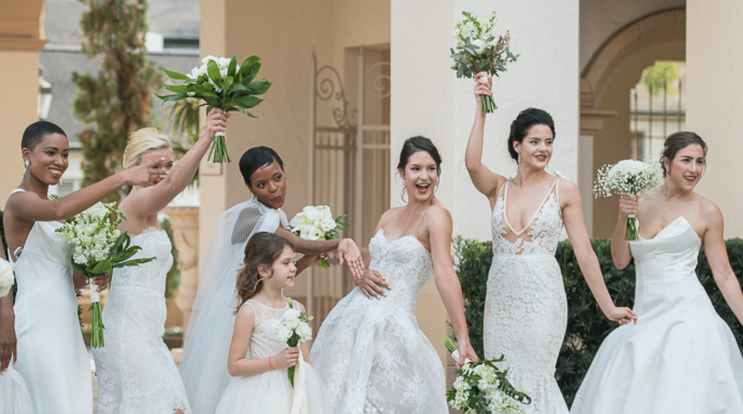 6 women in bridal dresses pictured with one flower girl