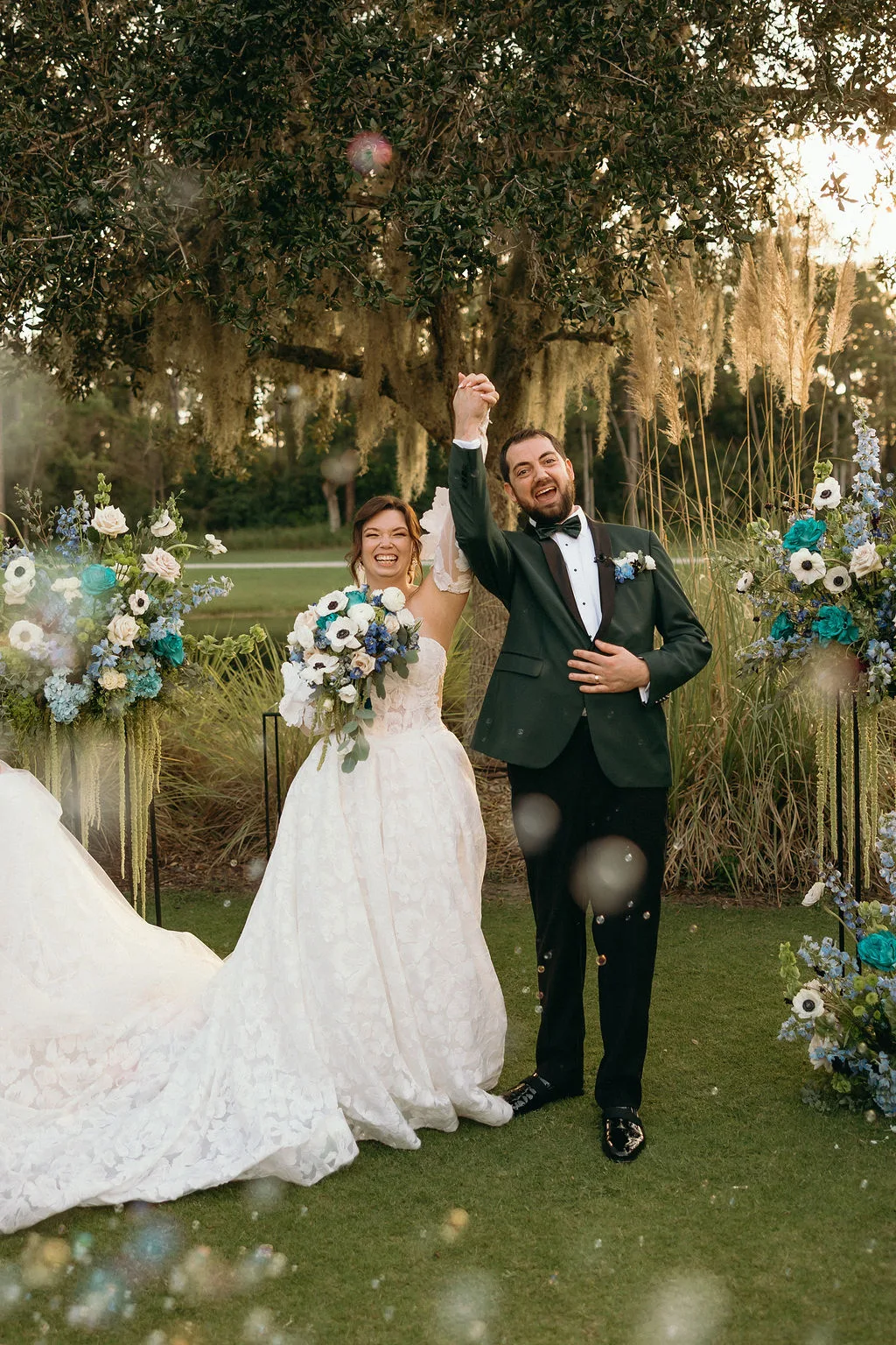 Newlyweds walking through blue, white, and green wedding flowers at Four Seasons Resort Orlando.
